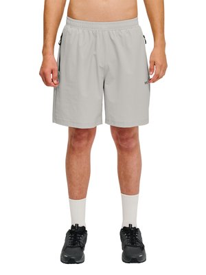 Mand iført lysegrå atletikshorts, hvide crew-sokker og sorte løbesko, stående mod en hvid baggrund.