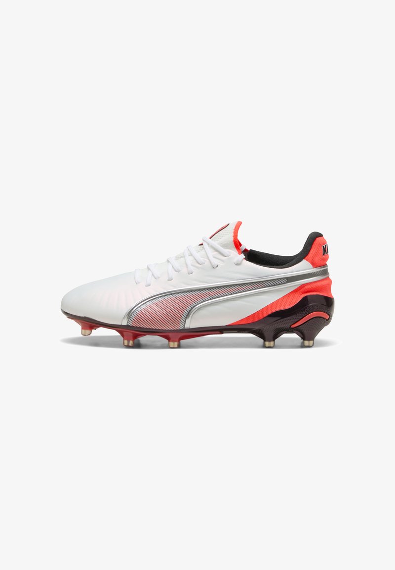 Crampons de football blancs avec des accents rouges et noirs, arborant un design élégant, une tige texturée, des rayures métalliques et une semelle à crampons.