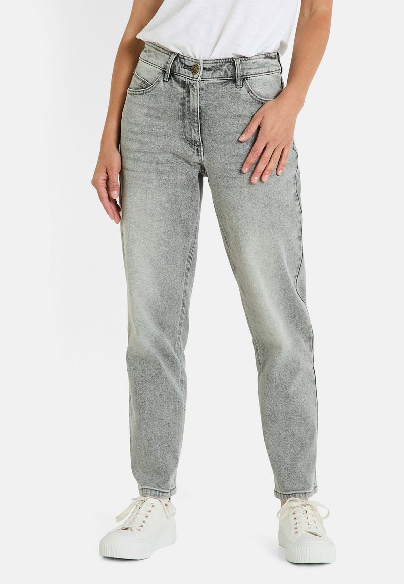 Jean taille haute gris clair avec un design à jambe droite, cinq poches et une fermeture à bouton métallique, associés à des sneakers blanches.