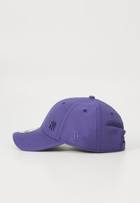 Boné de basebol roxo com uma aba curvada, logótipos bordados na frente e de lado, e orifícios de ventilação. Feito de um tecido suave.