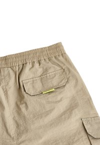 Bežové cargo šortky s elastickým pásom, so zadnou kapsou a neonovozeleným akcentom, vyrobené z mäkkého a ľahkého materiálu.