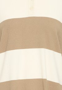 Polo en maille à rayures beige et crème avec une patte de boutonnage à trois boutons ; texture douce, coupe décontractée, et détails côtelés à l'ourlet et aux poignets.