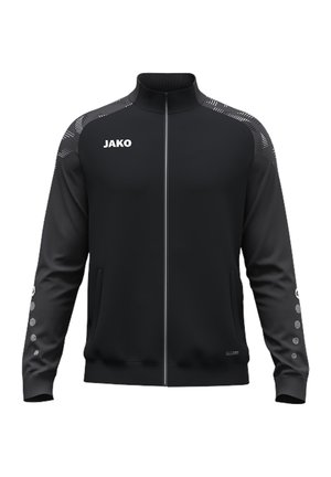 Veste de sport noire zippée intégralement avec col montant, bandes à motifs aux épaules, logo blanc JAKO sur la poitrine et points sur les manches.