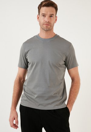 Graues T-Shirt mit kurzen Ärmeln und rundem Halsausschnitt, aus glattem Material gefertigt. Es zeichnet sich durch ein einfaches, figurnahes Design ohne Muster oder Verzierungen aus.
