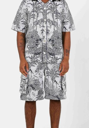 Ensemble chemise à manches courtes et shorts, motif floral noir et blanc. Boutonnage à l'avant avec une coupe décontractée, fabriqué en tissu léger.