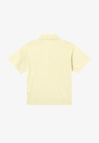 Polo manches courtes en maille côtelée jaune pâle, vu de dos, avec un col plat et une coupe régulière.