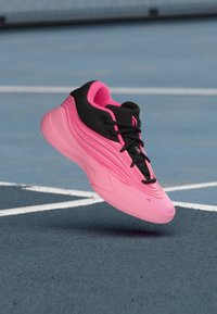 Różowe i czarne buty sportowe o smukłym designie, z falistymi wzorami oraz teksturowanym materiałem, sznurowane na czarno, z zaokrąglonym noskiem.
