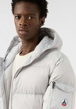 Hellgraue Steppjacke mit Kapuze, strukturierter Oberfläche, Reißverschlusstasche an der Seite und Logoaufnäher am Ärmel. Glatter Stoff und lockere Passform.