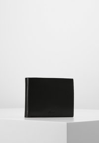 Portafoglio bifold in pelle nera con texture liscia, bordi arrotondati e branding discreto sul fronte. Design compatto e minimalista.