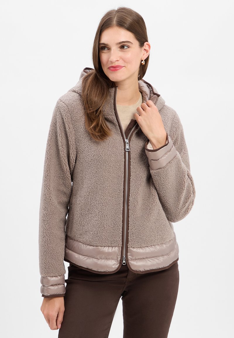 Fleece-lined hooded jacket in taupe with a zip front. Features a smooth, satin-like hem and cuffs. Textured exterior with a cozy appearance.