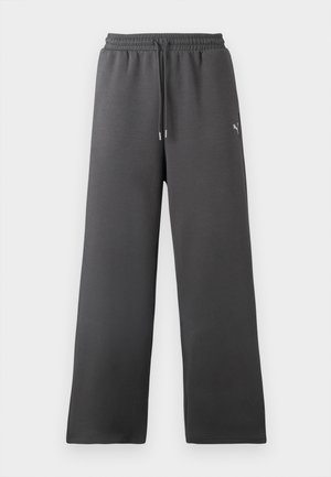 Pantaloni della tuta grigio scuro in tessuto morbido, con vita regolabile con coulisse, gambe larghe e un piccolo logo decorativo.