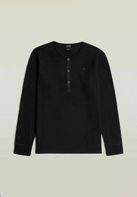 Sort langærmet henley-skjorte i vaffelstrik med tre knapper og ribstrikkede manchetter, med et diskret logo på venstre bryst.