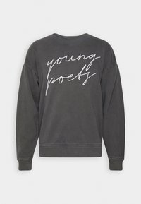 Sweat-shirt gris foncé avec texte cursif blanc "young poets" au dos, doté de manches longues et de poignets et ourlet côtelés.