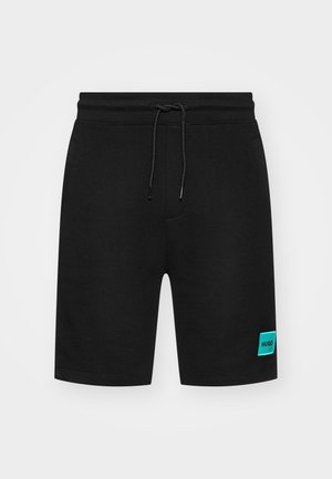 Mustat puuvillashortsit, joissa on säädettävä kiristysnauha vyötäröllä, sivutaskut ja turkoosi "HUGO" -logopatchi vasemmassa lahkeessa.