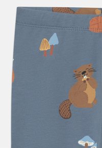 Tissu en coton bleu avec un motif de castor ludique et de champignons colorés. Présente une texture douce et des détails d'impression vibrants.