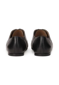 Schwarze Leder Schuhe mit niedrigem Absatz, runder Zehenform und minimalistischem Design. Glatte Textur und klare Linien, mit einer subtilen Nahtdetails auf der Rückseite.