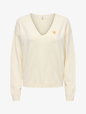 Crèmekleurige trui met lange mouwen, V-hals en een klein geel zonnetje op de linkerborst, ribgebreide manchetten en tailleband.