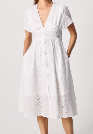 Weißes knielanges Kleid aus Lochstickerei mit kurzen Ärmeln, tiefem V-Ausschnitt, durchgeknöpftem Vorderteil und Händen in den Seitentaschen.