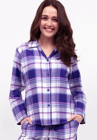 Fioletowy zestaw piżamowy w kratę, składający się z zapinanej na guziki koszuli z kołnierzykiem, długimi rękawami oraz pasujących spodni, wykonany z miękkiej, teksturowanej tkaniny.