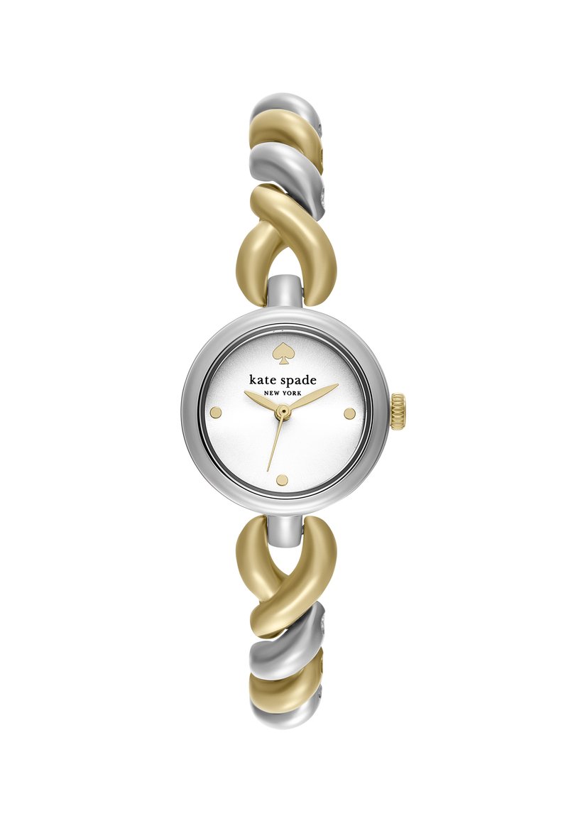 Hõbe- ja kuldse tooni keerduv sõrmuskell ümarate valge näo ja kuldsete tunni markeritega, millel on väike südametäpike kellal 12.