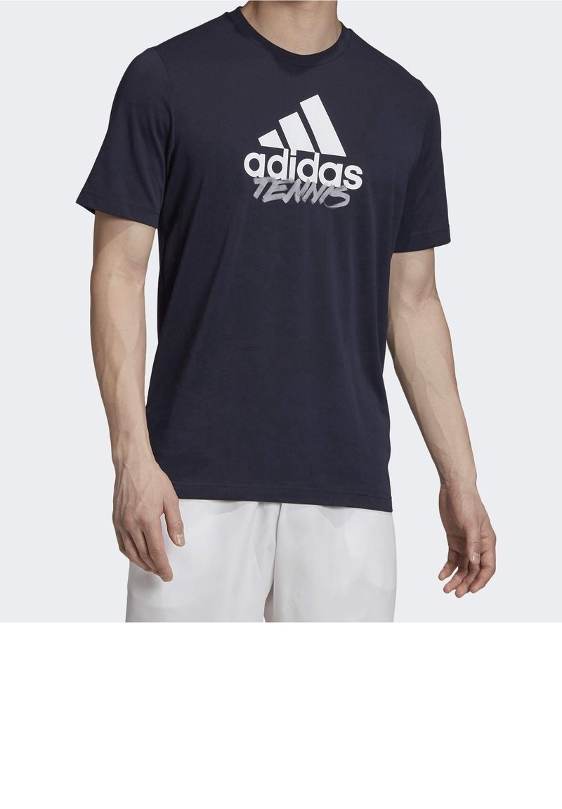 Tmavě modré bavlněné tričko s výrazným bílým logem adidas a textem "Tennis" přes hrudník, krátké rukávy a kulatý výstřih.