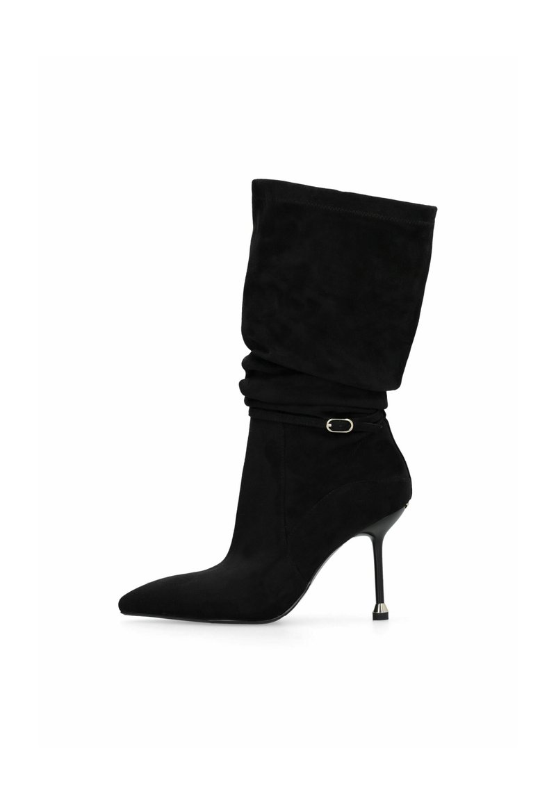 Stivaletti neri in suede con un'asta morbida, punta affusolata e tacco a stiletto sottile con un accento metallico vicino alla base.