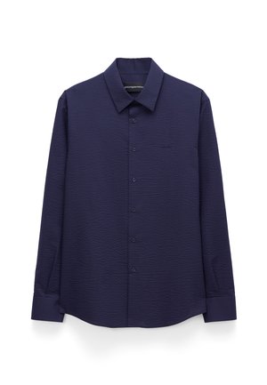 Camicia blu navy a manica lunga con bottoni, tessuto strutturato, colletto classico e polsini con bottoni, esposta su sfondo bianco.