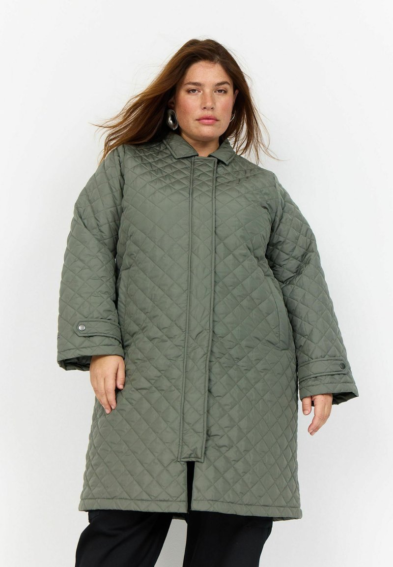 Cappotto esterno verde trapuntato con alta collana, maniche lunghe e bottoni frontali. Presenta una vestibilità ampia e un motivo a rombi testurizzato.