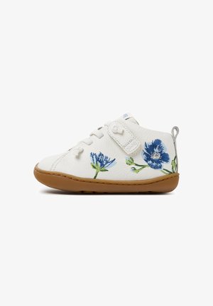 Scarpa bianca per bambino con ricamo di fiore blu, suola marrone chiaro, lacci bianchi e cinturino in Velcro su sfondo bianco.