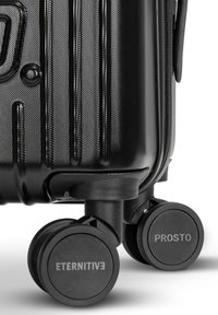 Czarna, twarda walizka z teksturowaną powierzchnią, wyposażona w dwa gładko toczące się, 360-stopniowe czarne koła oznaczone "ETERNITIVE" i "PROSTO."