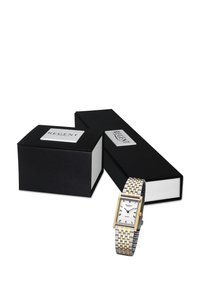 Montre rectangulaire en argent et en or avec un cadran blanc et des chiffres romains, positionnée à côté de boîtes de présentation noires étiquetées "REGENT".
