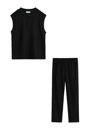Haut noir côtelé sans manches avec col rond et ensemble de pantalons assortis côtelés à taille élastique sur fond blanc.