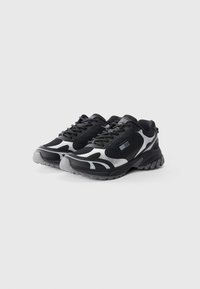 Black and gray athletic shoes with mesh upper, textured detailing, and curved design. Features laces and a contoured sole for stability.