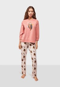 Pink long-sleeve sweatshirt with owl graphic, paired with cream pants featuring owl and moon patterns. Soft fabric, relaxed fit.