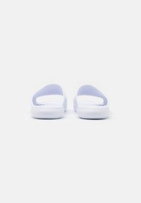 White slide sandals with open heel and toe design, featuring a smooth texture and rounded edges, designed for comfort and ease of wear.