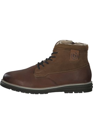 Brown leather and suede ankle boots with black laces, rubber sole, padded collar, and a logo patch on the side. Textured surface detail.