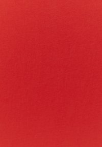 Roter Baumwollstoff mit glatter Textur und gleichmäßiger Oberfläche. Hervorgehoben wird eine leuchtende, einfarbige Farbe ohne Muster oder Verzierungen.