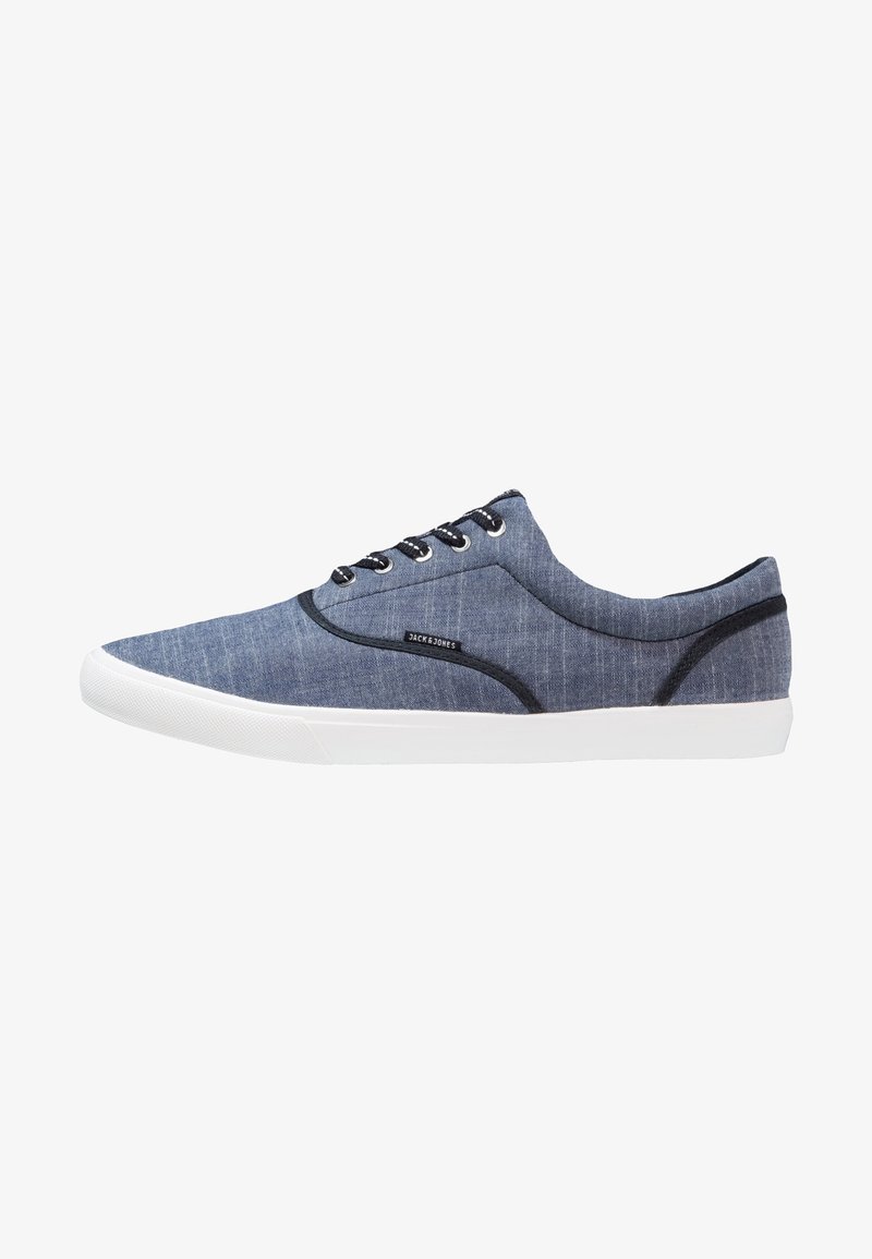Baskets basses bleues avec semelle blanche, bordure noire, lacets noirs et étiquette "Jack & Jones" sur le côté.