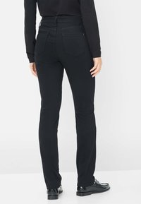 Zwarte broek met een aansluitend ontwerp, met een gemiddelde taillehoogte, vijf zakken en rechte pijpen, gemaakt van een gladde, elastische stof.