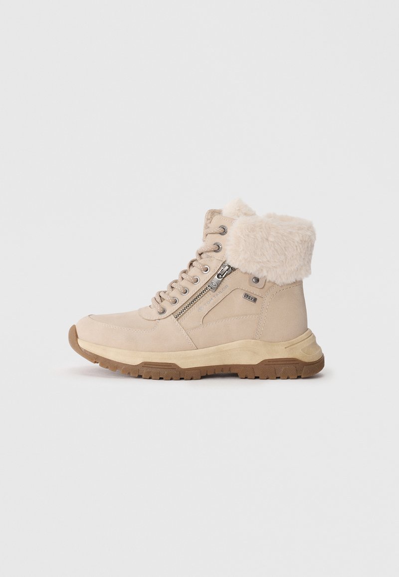 Beige ankelstøvler med en fluffy kant, i ruskind, snørebåndsdesign, lynlås i siden og en struktureret gummisål. Holdbare og varme.