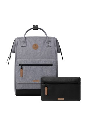 Grauer Stoff-Rucksack mit schwarzem Boden und vordere Tasche, kombiniert mit einem schwarzen, strukturierten Reißverschluss-Etui, beide mit braunen Reißverschlusszügen und Markenetiketten.