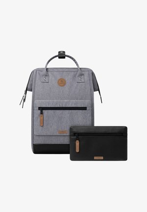 Gray fabric backpack with black bottom and front pocket, paired with a black textured zippered pouch, both with brown zipper pulls and brand labels.