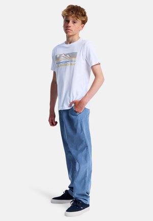 Vit t-shirt med kort ärm och färggrafisk bergsdesign, parat med ljusblå, raka jeans och marinblå sneakers.