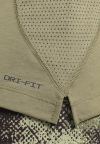 Oliivinvihreä Dri-Fit urheilu paita, jossa on teksturoitu, rei'itetty kangasosa V-muotoisella kuviolla ja ommelluilla reunoilla.