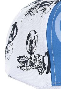 White baseball cap with black comic-style graphics, featuring illustrations and a blue side panel. Textured fabric with a structured shape.