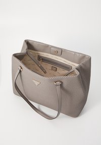 Sac fourre-tout tissé gris avec deux poignées de portage. Dispose d'un intérieur lisse avec une poche zippée et des accents de marque. Fermeture à glissière sur le dessus.
