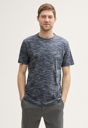 Korte mouwen marineblauw T-shirt met een gestructureerd patroon, ronde hals en een ontspannen pasvorm, gecombineerd met grijze broeken.