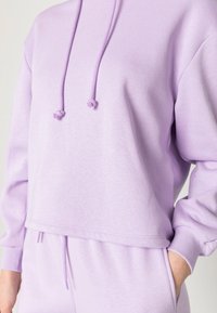 Ljuslila croppad hoodie med avslappnad passform, som har en dragsko i huvan, ribbade manschetter och mjukt, texturerat tyg.