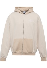 Beige zip-up hoodie lavet af blød bomuldsblanding. Har en kengurulomme, ribbede manchetter og et minimalistisk hvidt logo på brystet.