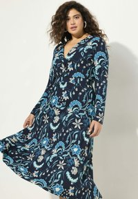 Granatowa sukienka z długimi rękawami, dekoltem w serek, zdobiona kwiecistym wzorem w jasnoniebieskim i kremowym kolorze. Luźna spódnica i dopasowana talia.